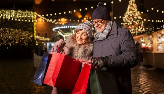 Couple out shopping at night surrounded by illuminations